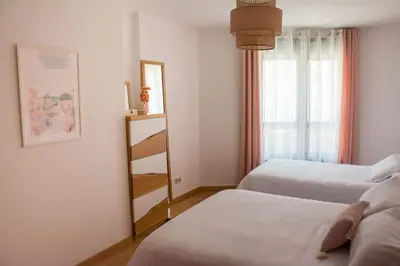 a bedroom with two beds and a window and a shelf at Alojamiento YASA in Sarria