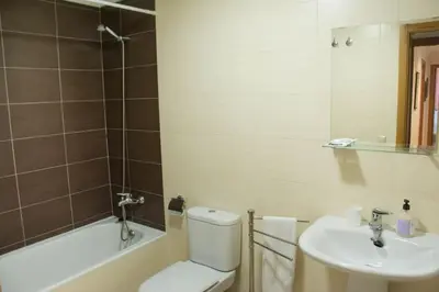a bathroom with a toilet and a sink and a tub at Alojamiento YASA in Sarria