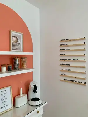 a kitchen with orange walls and a shelf with a coffee maker at Alojamiento YASA in Sarria