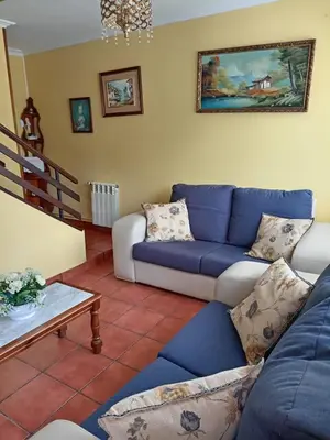 a living room with a blue couch and a table at Casa Alise in Ribadeo