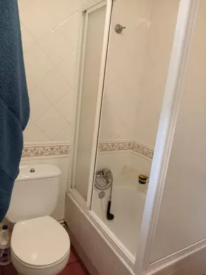 a bathroom with a white toilet and a shower at Casa Alise in Ribadeo