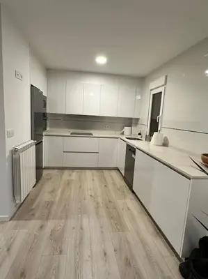 a large kitchen with white cabinets and wooden floors at Casa Bela II in Sales