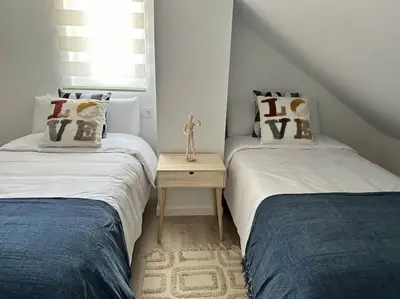 two twin beds in a room with a table at Casa Bela II in Sales
