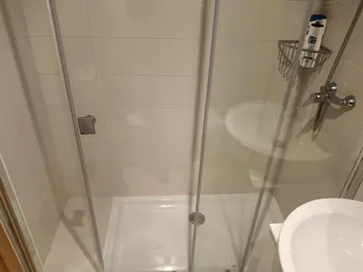 a shower with a glass door next to a sink at Apartamento en Puerto de Vega in Navia
