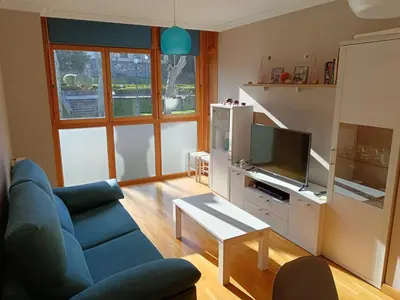 a living room with a blue couch and a tv at Apartamento en Puerto de Vega in Navia