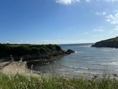 a beach with a body of water next to a cliff at Casa Playa de Rueta in Cervo
