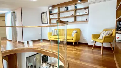a living room with a glass staircase and yellow chairs at The Cliffs - MarCastelos in Viveiro