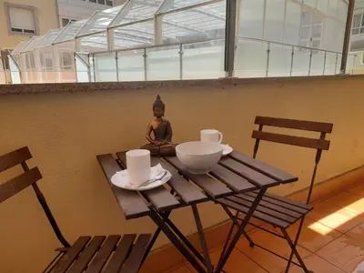 a wooden table with two chairs and a statue on it at EnViveiro a pie de Playa de Covas II in Viveiro