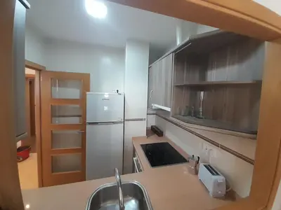 a kitchen with a sink and a refrigerator at EnViveiro a pie de Playa de Covas II in Viveiro