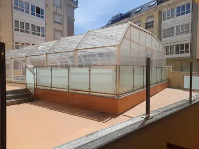 a glass greenhouse on a building in a city at EnViveiro a pie de Playa de Covas II in Viveiro