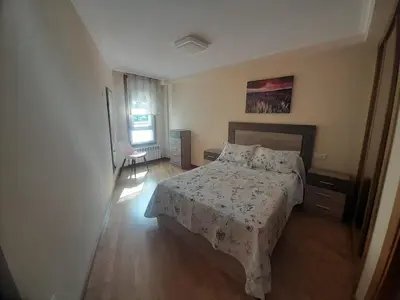 a bedroom with a bed and a chair in it at EnBURELA Tus Mejores Vacaciones in Burela de Cabo