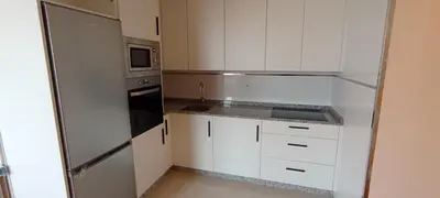 a kitchen with white cabinets and a stainless steel refrigerator at EnBURELA Tus Mejores Vacaciones in Burela de Cabo
