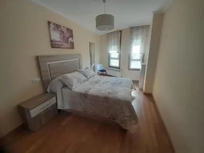 a bedroom with a bed and a wooden floor at EnBURELA Tus Mejores Vacaciones in Burela de Cabo