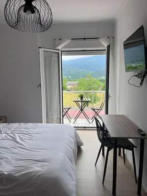 a bedroom with a bed and a table and a window at Dimar in Quiroga