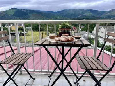 a table with bread and two chairs on a balcony at Dimar in Quiroga