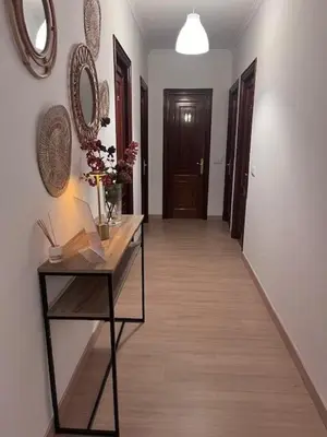 a hallway with a table with flowers and a mirror at Dimar in Quiroga