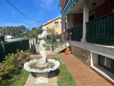 a statue of a woman standing in a yard at Casa As Bateas in Sada