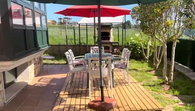 a table and chairs under an umbrella on a patio at Casa As Bateas in Sada