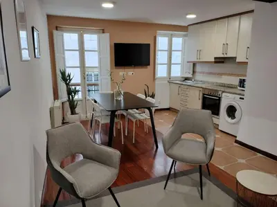 a living room with a table and chairs in a kitchen at A 100 metros Catedral, 3º -Galería -Duplex in Santiago de Compostela
