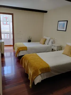 two beds in a hotel room with two beds at A 100 metros Catedral, 3º -Galería -Duplex in Santiago de Compostela