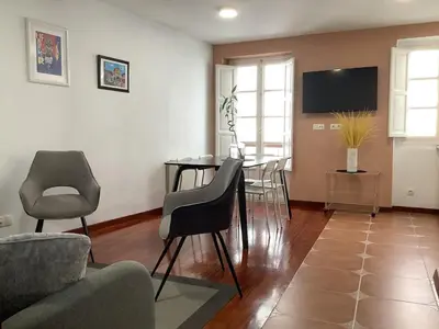 a living room with a table and chairs at A 100 metros Catedral, 3º -Galería -Duplex in Santiago de Compostela