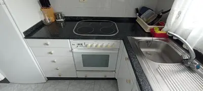 a kitchen with a stove top oven next to a sink at EnVIVEIRO Destino Playa de Covas in Viveiro