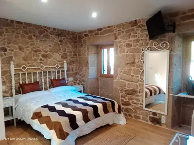 a bedroom with a large bed and a mirror at Casa Desigual in Padrón