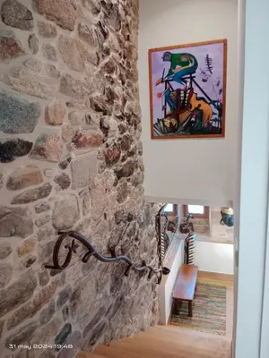 a stone wall in a hallway with a lamp at Casa Desigual in Padrón