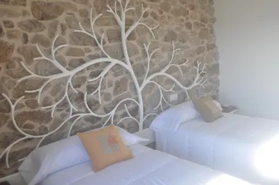 a bedroom with two beds and a tree mural at Casa Desigual in Padrón