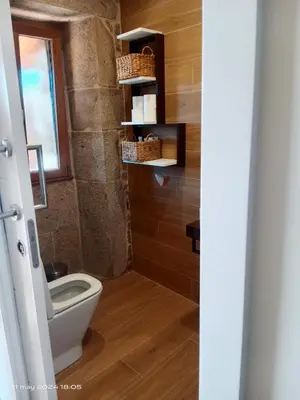 a bathroom with a white toilet in a room at Casa Desigual in Padrón