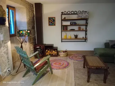 a living room with a green chair and a couch at Casa Desigual in Padrón