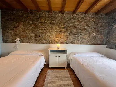 two beds in a room with a candle on a table at Casa Ramona en Ribeira Sacra in Lugo