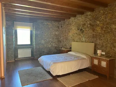 a bedroom with a bed and a stone wall at Casa Ramona en Ribeira Sacra in Lugo