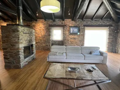a living room with a couch and a stone fireplace at Casa Ramona en Ribeira Sacra in Lugo