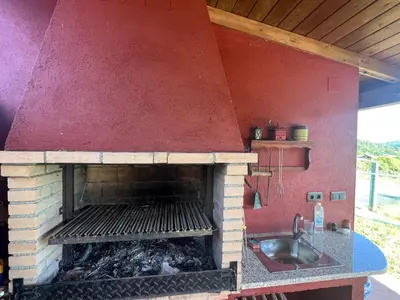 a kitchen with a brick oven with a sink at Casa Ramona en Ribeira Sacra in Lugo