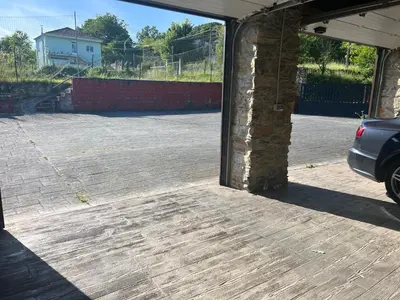 an open garage door with a car parked in a parking lot at Casa Ramona en Ribeira Sacra in Lugo