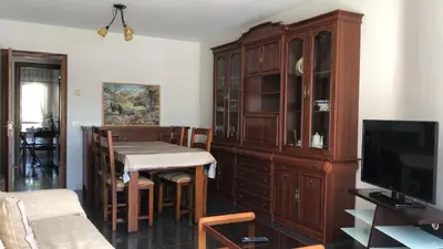 a dining room with a table and a wooden cabinet at Casa Vimar in Portomarin