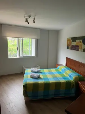 a bedroom with a bed with a colorful blanket at Casa Vimar in Portomarin