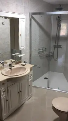 a bathroom with a sink and a shower with a mirror at Casa Vimar in Portomarin