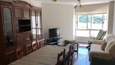 a living room with a table and a couch and a television at Casa Vimar in Portomarin