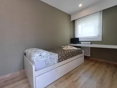 a small bedroom with a bed and a window at Villa Mayfa - alójate en pleno centro de Ourense in Ourense