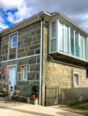 a brick house with a window and a table at Casa Carradas in Villarino Frío