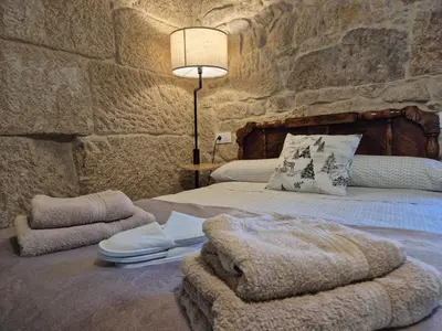 a bedroom with a bed with a blanket and a lamp at Casa Carradas in Villarino Frío