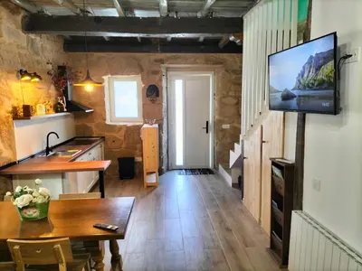 a kitchen and dining room with a television on a wall at Casa Carradas in Villarino Frío