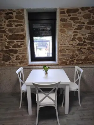 a white table and chairs in a room with a window at Casa Gallufe in Santiago de Compostela