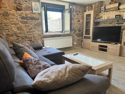 a living room with a couch and a tv at Casa Gallufe in Santiago de Compostela