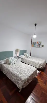 a room with two beds and a lamp at Apartamento Piñeirua in Ribadeo