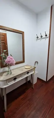 a bathroom with a vanity with a mirror on a wall at Apartamento Piñeirua in Ribadeo