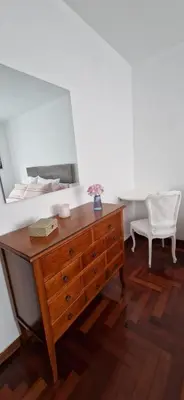 a dresser with a mirror and a chair in a room at Apartamento Piñeirua in Ribadeo