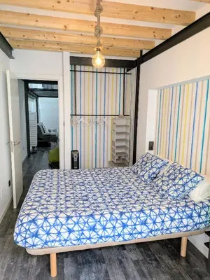 a bedroom with a bed with a blue comforter at VilafraggleRock, casa de diseño moderno en Pontedeume in Puentedeume